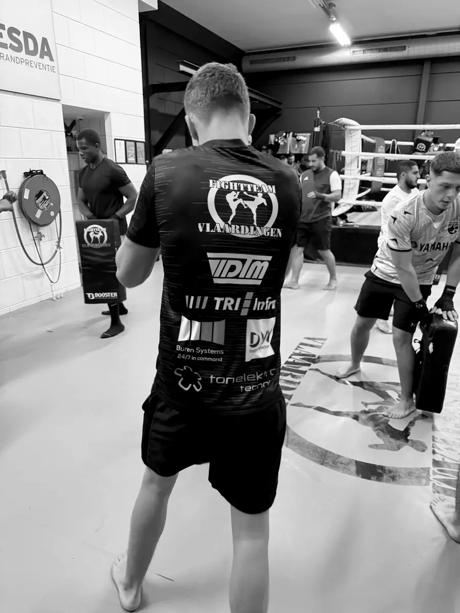 Een sporter in het shirt van Fightteam Vlaardingen houdt het trapkussen vast
